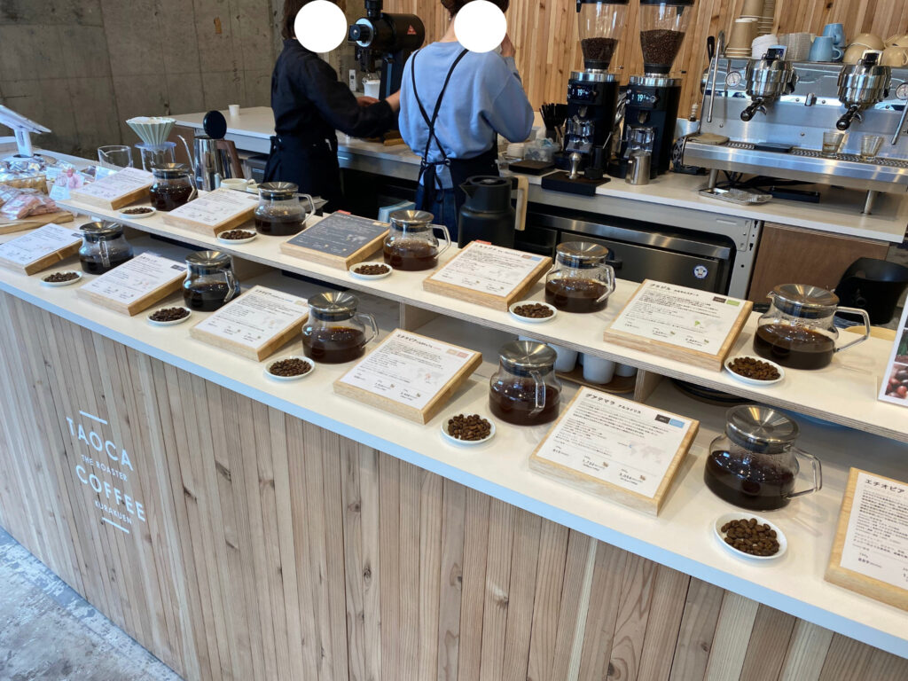 TAOCA COFFEE 神戸六甲店に並ぶコーヒー豆とそれらの説明
コーヒー豆が並ぶカウンターの奥にはキッチン。
店員がコーヒーを淹れてくれている。