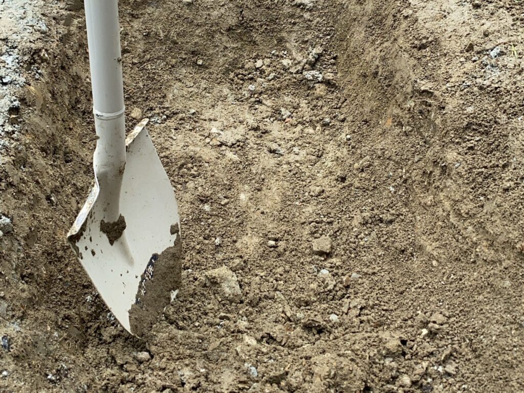 花壇を作りたい場所に穴を掘っているところ。穴とスコップ。